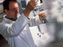 T8750787-Male_chemist_in_lab_pipettes_liquid_into_a_flask-SPL